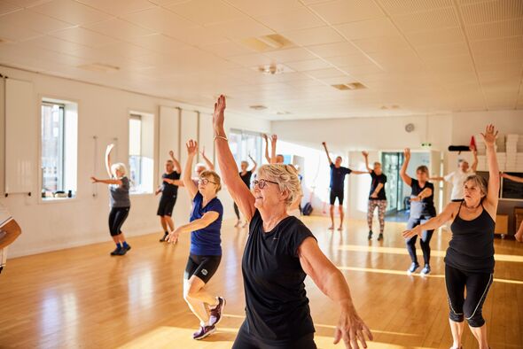 Smiling senior citizen taking exercise class at gym Smiling senior citizen taking exercise class at gym
